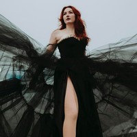 Inilah penampilan Lauren dengan gaun pengantin hitamnya. Gaun berpotongan off-shoulder tersebut memiliki lengan tulle. Bagian atas yang dibuat aksen korset dengan bagian roknya yang bervolume dari bahan tulle. Foto: dok. Instagram (fotografer: @caitlinconnell.photo)