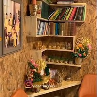Bagian dalam rumah yang didominasi oleh warna coklat keemasan itu juga memiliki rak dinding untuk menyimpan buku-buku. Di samping rak dinding tersebut terpajang foto keluarga sang pemilik rumah. Foto: Instagram/@video_medsos