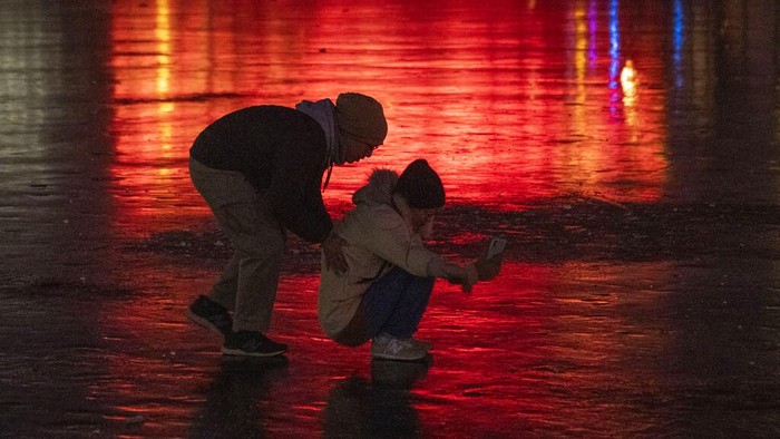 Residents play on a frozen lake near the Olympics Green in Beijing, China, Monday, Jan. 3, 2022. (AP Photo/Ng Han Guan)