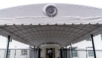 Salju terlihat di segel Presiden di atas pintu masuk Sayap Barat Gedung Putih di Washington.