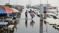 Warga beraktivitas saat terjadinya banjir rob di Pelabuhan Kali Adem, Muara Angke, Jakarta.