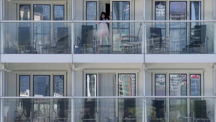 Hong Kong Cruise Passengers look out from the Spectrum of the Seas cruise ship docked at Kai Tak cruise terminal in Hong Kong Wednesday, Jan. 5, 2022. Thousands of passengers were being held Wednesday on the cruise ship in Hong Kong for coronavirus testing after health authorities said nine passengers were linked to a recent omicron cluster and ordered the ship to turn back. (AP Photo/Vincent Yu)