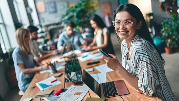Group of young business people are working together in modern office. Creative people with laptop, tablet, smart phone, notebook. Successful hipster team in coworking. Freelancers.