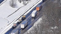 Truk derek menuju ke mobil yang terdampar dan truk terdampar di bagian Interstate 95. AP/Steve Helber