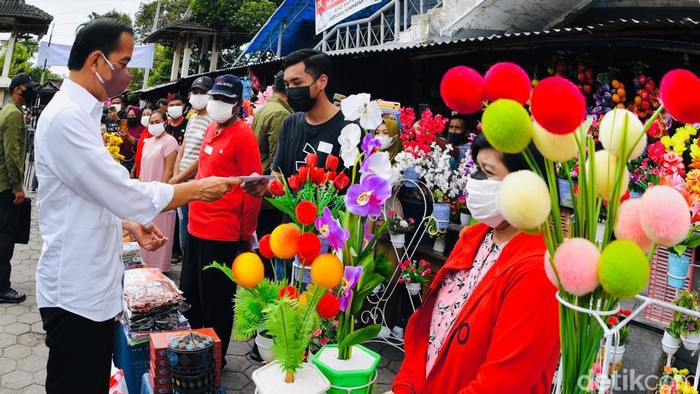 Presiden Joko Widodo menyapa para pedagang di Pasar Umum Purwodadi, Grobogan, Rabu (5/1/2022)