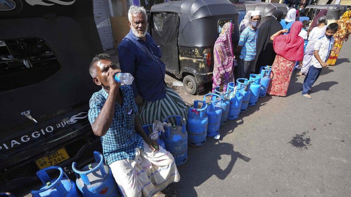 Kekurangan Pasokan Gas, Warga Sri Lanka Antre Panjang Warga Sri Lanka mengantre untuk mengisi ulang tabung gas memasak mereka saat terjadi kekurangan pasokan di Kolombo, Sri Lanka, Selasa, 4 Januari 2022. (AP Photo/Eranga Jayawardena)