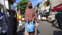 Seorang wanita Sri Lanka menunggu antrian untuk isi ulang tabung gas.
