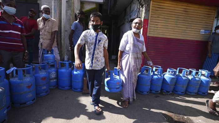 Kekurangan Pasokan Gas, Warga Sri Lanka Antre Panjang Warga Sri Lanka mengantre untuk mengisi ulang tabung gas memasak mereka saat terjadi kekurangan pasokan di Kolombo, Sri Lanka, Selasa, 4 Januari 2022. (AP Photo/Eranga Jayawardena)