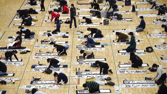 Participants show their works of traditional Japanese calligraphy during the annual New Year's calligraphy contest at the Budokan martial arts hall Wednesday, Jan. 5, 2022, in Tokyo. (AP Photo/Eugene Hoshiko)