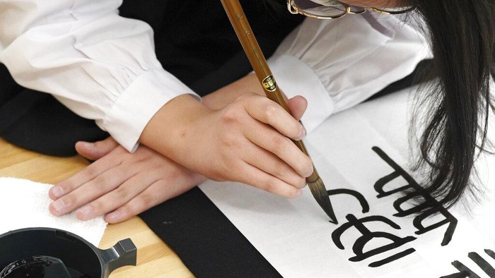 Participants show their works of traditional Japanese calligraphy during the annual New Year's calligraphy contest at the Budokan martial arts hall Wednesday, Jan. 5, 2022, in Tokyo. (AP Photo/Eugene Hoshiko)