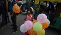 Gadis penjual balon di New Delhi, India (24/12/2021). (AP Photo/Altaf Qadri)