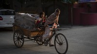 Seorang pemulung mengayuh gerobak sepeda di sebuah pasar di New Delhi, India (31/12/2021). (AP Photo/Altaf Qadri)