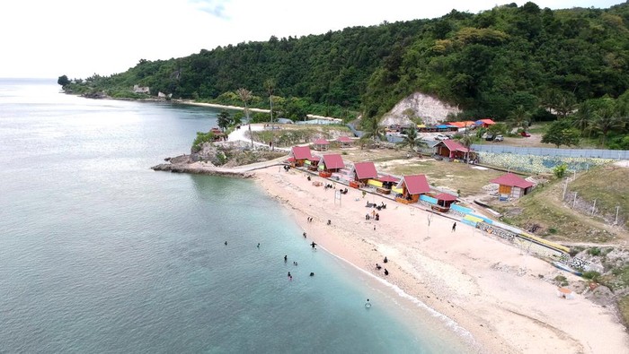 Foto udara objek wisata Pantai Tilalohe di Desa Biluhu Timur, Kabupaten Gorontalo, Gorontalo, Rabu (5/1/2022). Destinasi wisata baru tersebut memiliki pantai berpasir putih, sejumlah penginapan, lokasi selam permukaan (snorkeling) dan bukit untuk berkemah. ANTARA FOTO/Adiwinata Solihin/wsj.