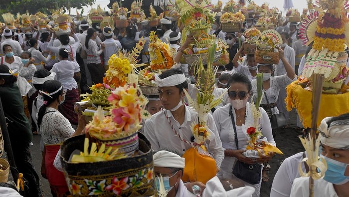 Sejumlah umat Hindu membawa perangkat upacara yang merupakan simbol arwah anggota keluarganya dalam upacara Nyegara Gunung di Pantai Goa Lawah, Klungkung, Bali, Selasa (4/1/2022). Upacara yang dilaksanakan setelah Ngaben atau kremasi jenazah tersebut merupakan ritual tahap akhir berupa doa-doa dan penyucian terhadap 214 arwah. ANTARA FOTO/Nyoman Budhiana/tom.