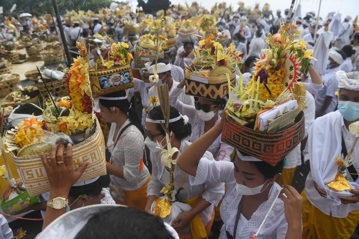 Sejumlah umat Hindu membawa perangkat upacara yang merupakan simbol arwah anggota keluarganya dalam upacara Nyegara Gunung di Pantai Goa Lawah, Klungkung, Bali, Selasa (4/1/2022). Upacara yang dilaksanakan setelah Ngaben atau kremasi jenazah tersebut merupakan ritual tahap akhir berupa doa-doa dan penyucian terhadap 214 arwah. ANTARA FOTO/Nyoman Budhiana/tom.