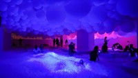 Orang-orang berenang di kolam bola dalam pameran seni Lets Fly di Museum Balon Roma.