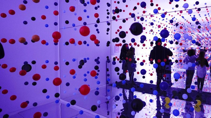 People swim in a ball pool in an art exhibition called 'Let's Fly' in the Rome's Balloon Museum, composed entirely of balloon and inflatable artworks, Wednesday, Jan. 5, 2022. (AP Photo/Alessandra Tarantino)