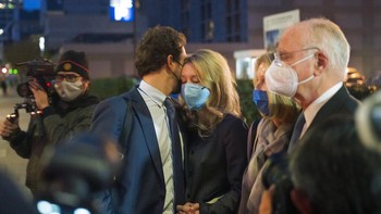 Sang suami berusaha menenangkan istrinya usai proses pengadilan yang melelahkan. Foto: AP