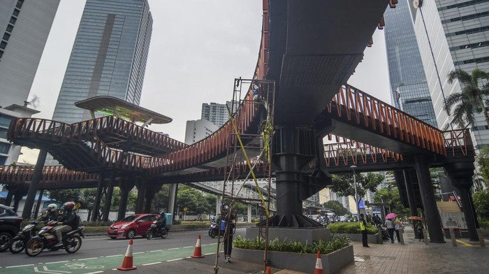 Hampir Rampung, Begini Penampakan JPO Pinisi di Sudirman Warga melintas disamping proyek jembatan penyebrangan orang (JPO) Pinisi di kawasan Sudirman, Jakarta, Kamis (6/1/2022). JPO berkonsep Kapal Pinisi saat ini progresnya sudah mencapai 98 persen dan memasuki tahap penyelesaian akhir. ANTARA FOTO/Galih Pradipta/foc.