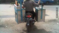 Tak mau telat tiba di pangkalan, penjual telur ini naik ojak sekaligus bawa gerobaknya di pikul. Foto: Instagram /Facebook