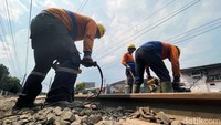 Sejumlah petugas PT KAI melakukan pemadatan batu bantalan rel (ballast) di jalur rel kereta api kawasan Buaran, Jakarta Timur, Kamis (06/01/2022).