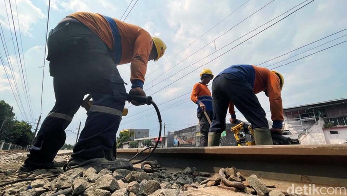 Sejumlah petugas PT KAI melakukan perawatan jalur rel kereta api di kawasan Buaran, Jakarta Timur. Mereka melakukan pemadatan batu bantalan rel (ballast).