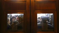 Tepat sebelum pukul 2 siang waktu setempat, banyak perusuh berhasil mencapai pintu dan jendela Capitol. Kerumunan itu memaksa untuk masuk, sekelompok perusuh menggunakan sepotong kayu untuk mendobrak jendela. Beberapa juga terlihat sampai memanjat ke dalam gedung. (AP/Andrew Harnik)