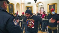 Saat perusuh mulai menyerbu Capitol dan bangunan lain di sekitarnya, beberapa penghuni bangunan di kompleks mulai dievakuasi. Di luar, massa membobol ban kendaraan polisi, dan meninggalkan catatan untuk Ketua DPR, Nancy Pelosi.  (AP/Manuel Balce Ceneta)