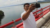 Dari atas jembatan, wisatawan bakal disuguhkan dengan pemandangan teluk Youtefa dan pegunungan Skyline. Daratan Papua Nugini pun terlihat dari sini. Pantas jika banyak wisatawan berfoto di sini. (Yudha Maulana/detikTravel)