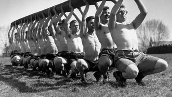 Tentara AS berlatih kekuatan dengan mengangkat tiang telegraf pada masa Perang Dunia II, April 1942. (Photo by George W. Hales/Fox Photos/Getty Images)