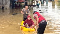 Petugas kepolisian mengevakuasi warga yang terjebak banjir di Pasar Youtefa Abepura, Jayapura, Papua. (ANTARA FOTO/azhar)