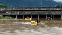 Seorang warga menaiki perahu saat banjir di Pasar Youtefa Abepura, Papua. (ANTARA FOTO/Adharnazamudin)