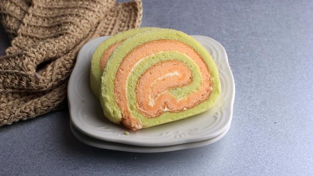 Bolu Gulung or Roll Cake Pandan and Strawberry with Vanilla Cream. Sliced. Served on White Background, Copy Space