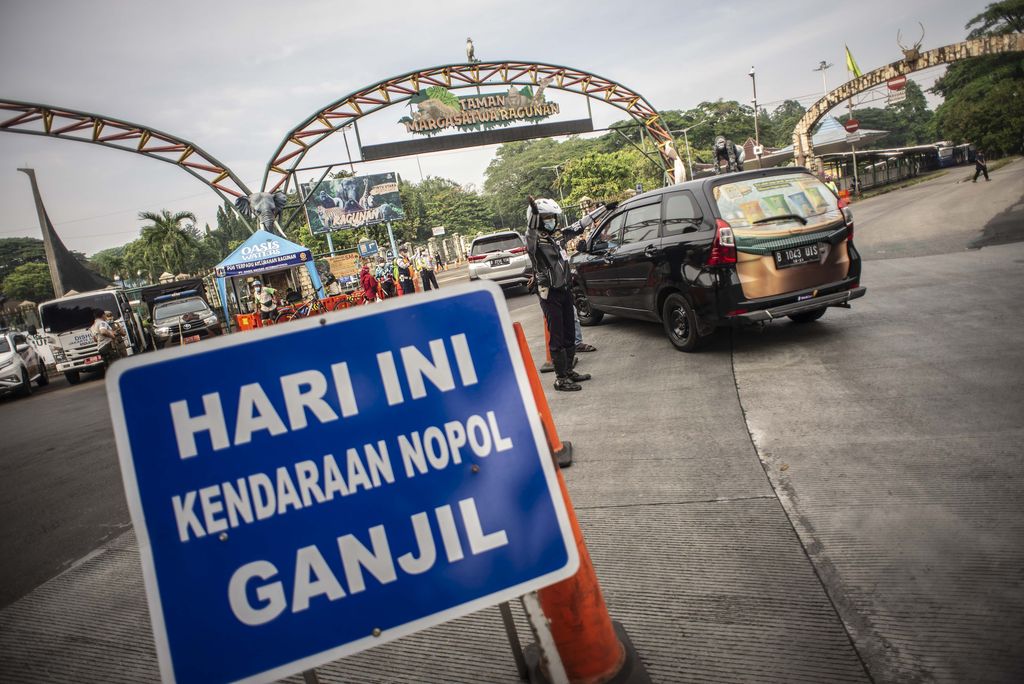 Petugas Dishub DKI Jakarta mengatur arus lalu lintas di depan pintu masuk Taman Margasatwa Ragunan, Jakarta, Sabtu (23/10/2021). Dinas Perhubungan DKI Jakarta menerapkan kebijakan pelat nomor polisi ganjil genap pada kendaraan roda empat di tempat wisata edukasi Taman Margasatwa Ragunan yang berlaku mulai 22 Oktober 2021 saat penerapan Pemberlakuan Pembatasan Kegiatan Masyarakat (PPKM) level dua di Ibu Kota. ANTARA FOTO/Aprillio Akbar/wsj.