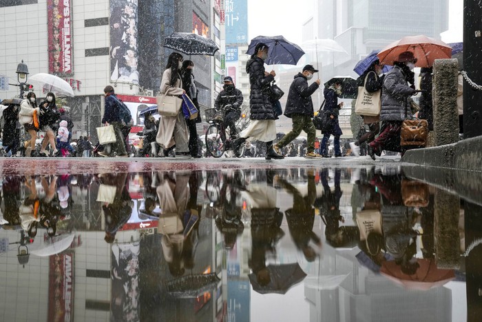 Hujan Salju Tokyo People walk across at the famed Shibuya scramble crossing as the snow comes down Thursday, Jan. 6, 2022, in Tokyo. Japanese Foreign Minister Yoshimasa Hayashi on Thursday asked that the U.S. military in Japan stay inside its bases to prevent the further spread of COVID-19. Prime Minister Fumio Kishida said he has decided to tighten virus restrictions in Okinawa, Yamaguchi prefecture, where US bases are located, and Hiroshima.(AP Photo/Kiichiro Sato)