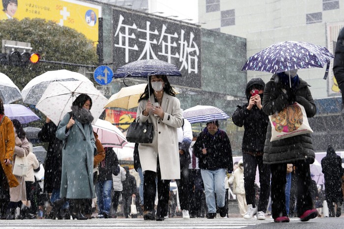 Hujan Salju Tokyo People walk across at the famed Shibuya scramble crossing as the snow comes down Thursday, Jan. 6, 2022, in Tokyo. Japanese Foreign Minister Yoshimasa Hayashi on Thursday asked that the U.S. military in Japan stay inside its bases to prevent the further spread of COVID-19. Prime Minister Fumio Kishida said he has decided to tighten virus restrictions in Okinawa, Yamaguchi prefecture, where US bases are located, and Hiroshima.(AP Photo/Kiichiro Sato)