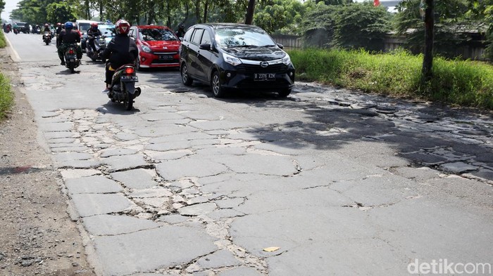 Pengendara melintasi jalanan yang rusak di Jalan Inspeksi Kalimalang, Tambun Selatan, Kabupaten Bekasi, Jawa Barat, Jumat (7/1/2021). Jalan yang rusak dapat menyebabkan rawan kecelakaan lalu lintas. Kerusakan yang terjadi kurang lebih sepanjang 75 meter.