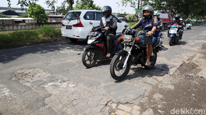Pengendara melintasi jalanan yang rusak di Jalan Inspeksi Kalimalang, Tambun Selatan, Kabupaten Bekasi, Jawa Barat, Jumat (7/1/2021). Jalan yang rusak dapat menyebabkan rawan kecelakaan lalu lintas. Kerusakan yang terjadi kurang lebih sepanjang 75 meter.