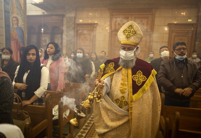 Misa Natal Bishop Dawod Makram wears a face mask, to help prevent the spread of the coronavirus, as he leads the Coptic Orthodox Midnight Mass on Orthodox Christmas Eve at Church of St. George in Cairo, Egypt, late Thursday, Jan. 6, 2022. Copts celebrate Christmas according to the Julian calendar, meaning it falls on Jan. 7. (AP Photo/Amr Nabil)