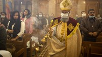 Uskup Dawod Makram menggunakan masker saat memimpin misa Natal di Gereja Koptik Ortodoks, Kairo, Mesir (6/1/2022) malam. Mereka memperingati Natal tanggal 7 Januari karena menyesuaikan sistem penanggalan Julian. (AP Photo/Amr Nabil)