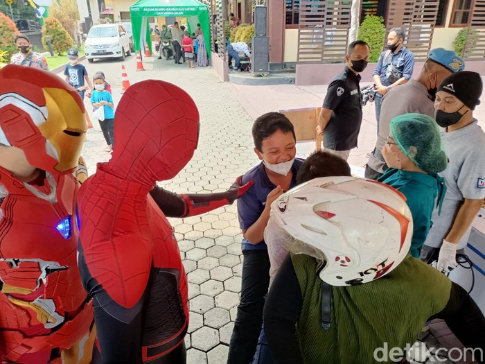 Vaksinasi anak usia 6-11 tahun digelar Polres Probolinggo Kota dengan sistem drive thru. Agar tidak tegang, anak-anak dihibur badut, super hero hingga disediakan foto booth dengan motor gede atau moge.