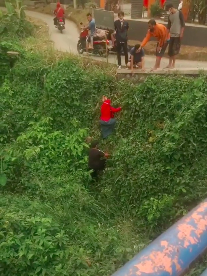 Video seorang ibu-ibu merangkak naik dari tepi kali di Pitara, Depok, ramai beredar. Ibu-ibu itu terjatuh ke kali usai sepeda motornya yang ditumpanginya mengalami kecelakaan. (Nahda RU/detikcom)