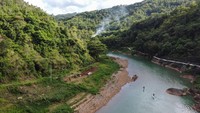 Pengunjung bermain Stand Up Paddle di Sungai Oyo, Selopamioro, Imogiri, Bantul, DI Yogyakarta, Jumat (7/1/2022).