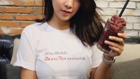 Segelas es cokelat sulit ditolak Dinda. Sebelum menyeruputnya, ia lebih dulu berpose sambil memegang segelas minuman dingin ini. Selain hobi makan, Dinda juga hobi masak lho! Foto: Instagram @dindakirana.s