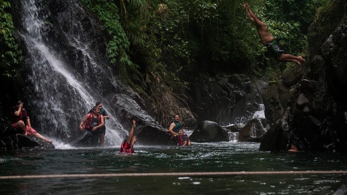 Sejumlah wisatawan bermain air di Wisata Black Canyon, Petungkriyono, Kabupaten Pekalongan, Jawa Tengah, Sabtu (8/1/2022). Wisata air terjun dengan dinding bebatuan alam berwarna hitam yang dikelola oleh kelompok sadar wisata (Pokdarwis) setempat itu menjadi salah satu tujuan liburan favorit di Kabupaten Pekalongan saat akhir pekan. ANTARA FOTO/Harviyan Perdana Putra/rwa.