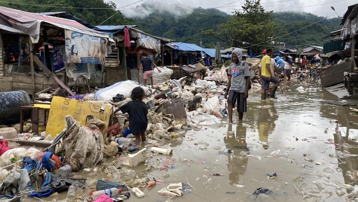 Warga berada didekat bangunan yang rusak akibat banjir di Pasar Youtefa, Abepura, Jayapura, Papua, Minggu (9/1/2022). Aktivitas Pasar Youtefa mulai berjalan kembali pascabanjir yang melanda sejumlah wilayah di Jayapura pada Jumat (7/1/2022). ANTARA FOTO/Adharnazamudin/wpa/YU