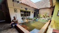Warga menunjukan sebuah kolam ikan yang berada di dalam rumah.