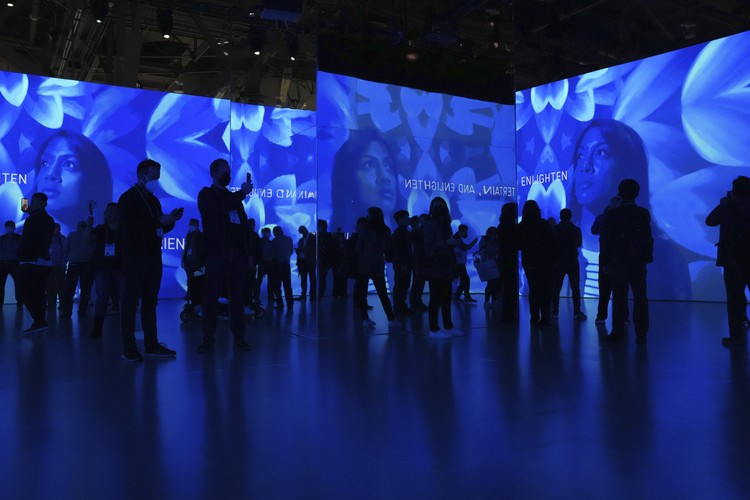 FILE - Attendees view projected images at an immersive entertainment theater exhibit at the Panasonic booth during the CES tech show, Wednesday, Jan. 5, 2022, in Las Vegas. The thousands of people who gathered in Las Vegas for this weeks CES gadget show were a fraction of the usual crowd for the influential tech conference, the events organizer said Friday, Jan. 7. The Consumer Technology Association said on the shows closing day that more than 40,000 people attended the multi-day event on the Las Vegas Strip. (AP Photo/Joe Buglewicz, File)