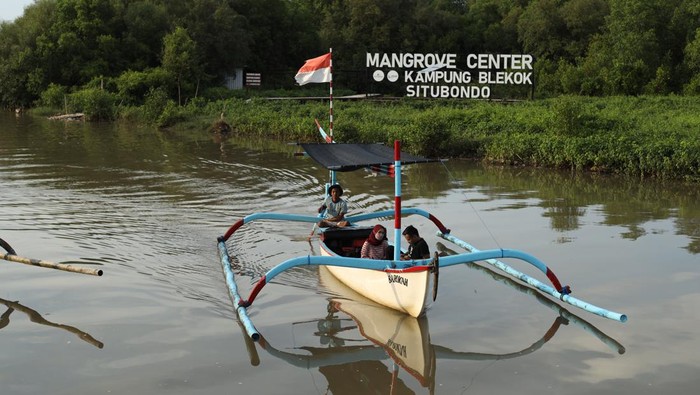 Wisatawan naik perahu untuk menjelajahi hutan mangrove di Kampung Blekok, Situbondo, Jawa Timur, Sabtu (8/1/2021). Kawasan konservasi hutan mangrove seluas 27 hektar itu merupakan habitat bagi 11 jenis burung air yang menjadi daya tarik wisatawan untuk berkunjung. ANTARA FOTO/Budi Candra Setya/rwa.
