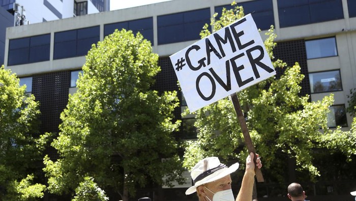 A fan of Serbia's Novak Djokovic stands outside the Park Hotel, used as an immigration detention hotel where the world's No. 1-ranked tennis player is detained in Melbourne, Australia, Sunday, Jan. 9, 2022. After four nights in hotel detention Djokovic will get his day in court on Monday in a controversial immigration case that has polarized opinions in the tennis world and elicited heartfelt support for the star back home in his native Serbia. Djokovic was denied entry at Melbourne airport last week after border officials canceled his visa for failing to meet its entry requirement that all non-citizens be fully vaccinated for COVID-19. (AP Photo/Hamish Blair)